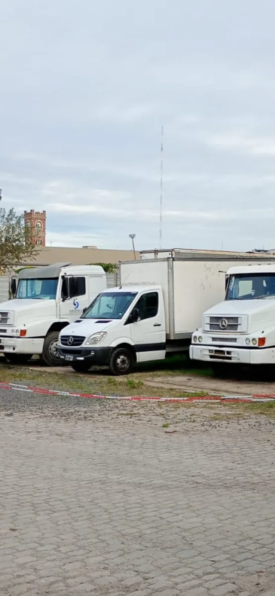Tres camiones de la flota de Mudandome estacionados en el playón