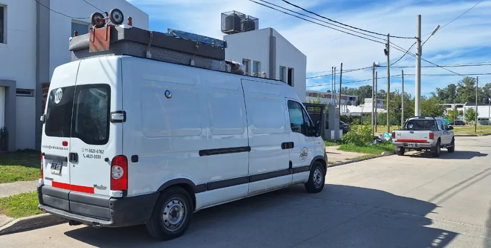 Utilitario de Mudandome con carga en un barrio residencial